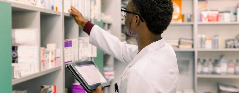 Pharmacist finding prescribed medicine at pharmacy