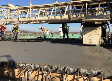 construction workers smoothing out concrete for Dallas Parkway