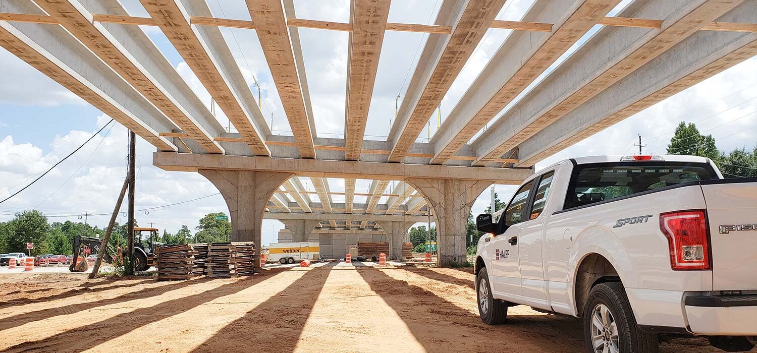 truck parked beneath bridge beams for SH 249 Tomball Tollway