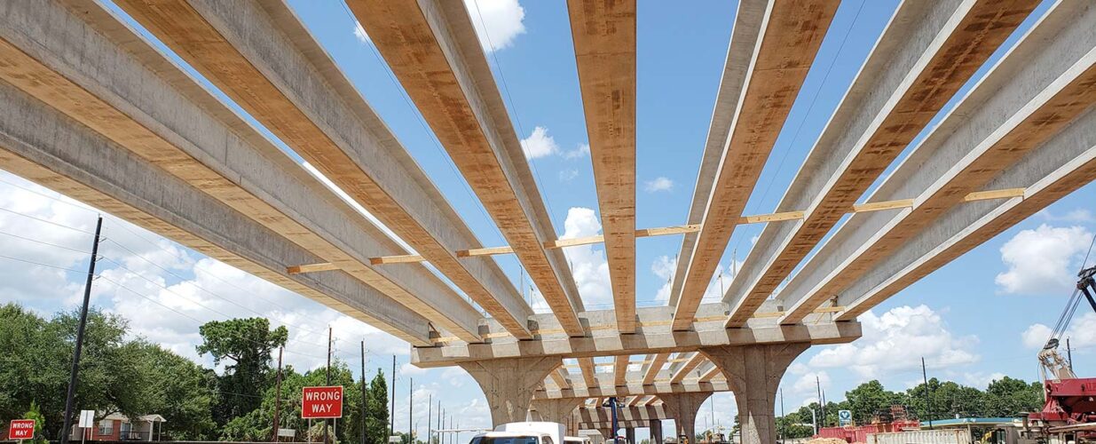bridge beams across the sky with truck parked underneath SH 249 tollway