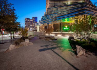 Rolex Building plaza at night with Dallas cityscape