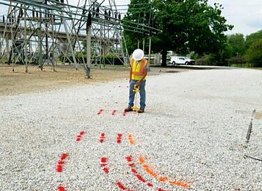 field crew member painting lines on road