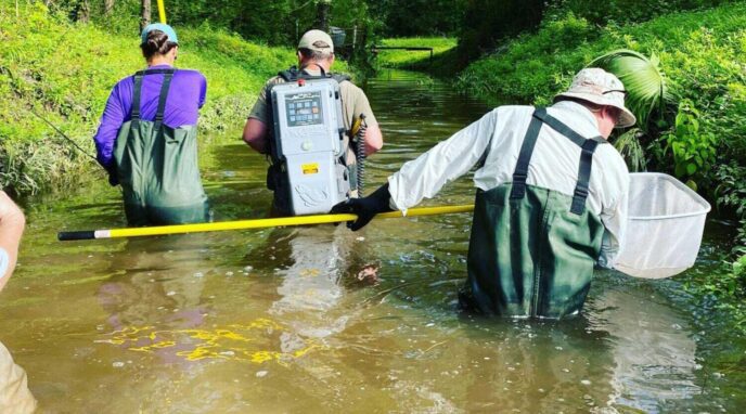 crew members wading in water performing environmental constraints analysis