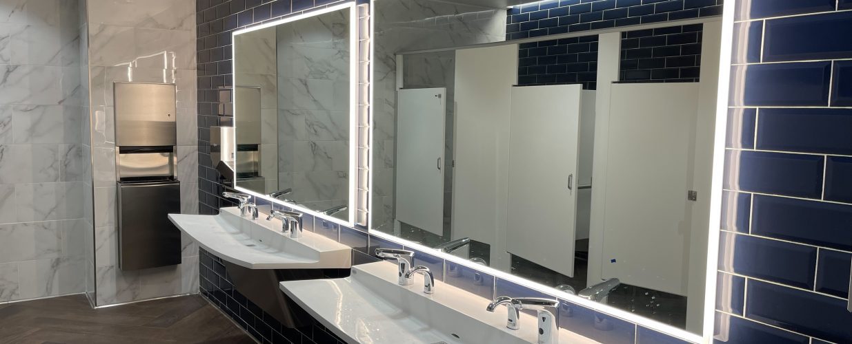 Bathroom sinks and mirrors with warm lights at Brownsville PUB New Annex Building