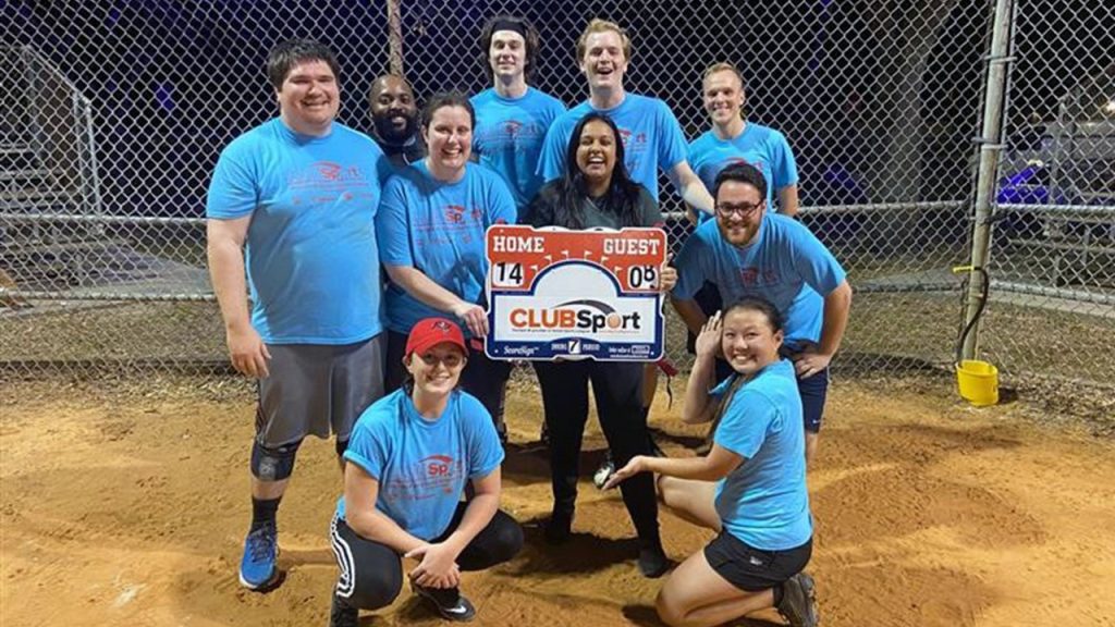 Halff's Tampa office kickball team celebrating their win holding the scoreboard sign