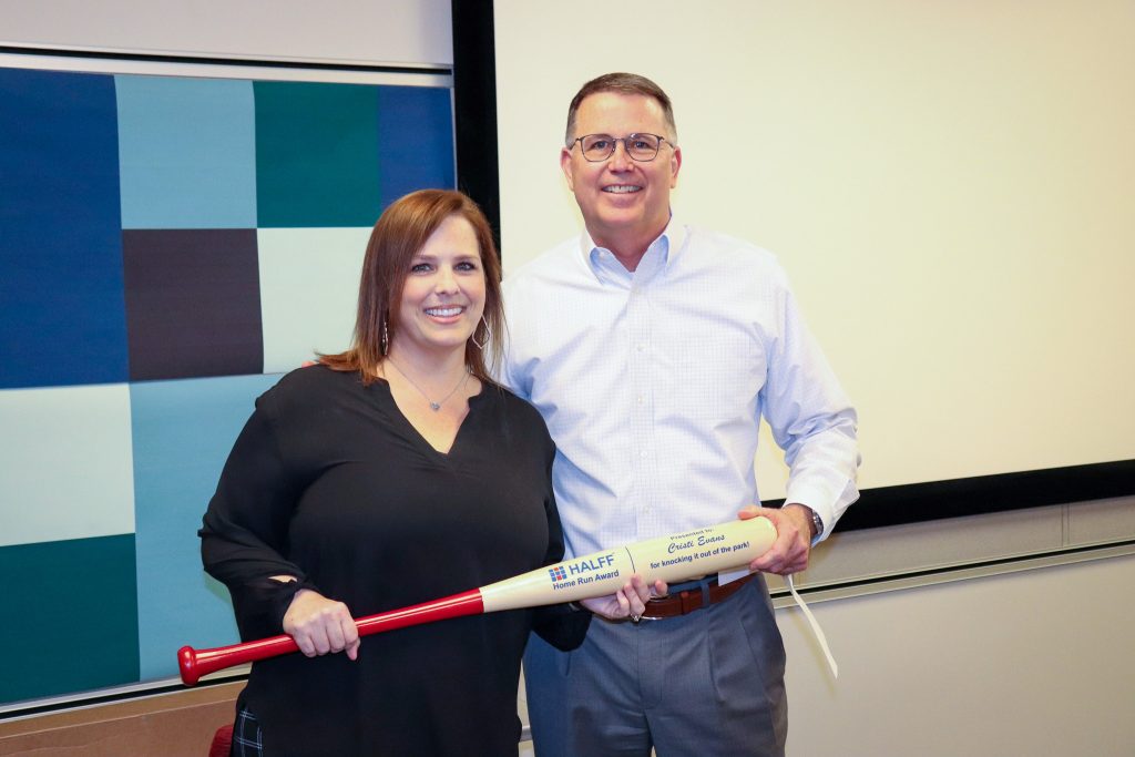 Halff's President/CEO awarding Benefits Analyst Cristi Evans with Home Run baseball bat Award