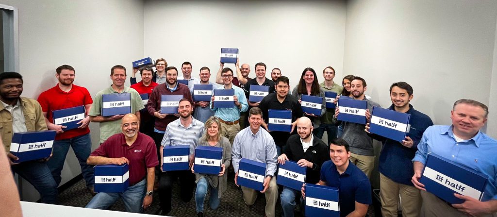 Frisco Halff employees celebrating rebrand with blue branded gift boxes