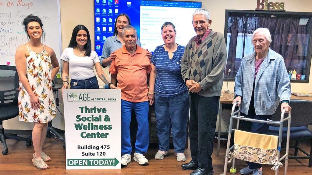 Halff employees taking a picture of AGE senior residents after delivering donations