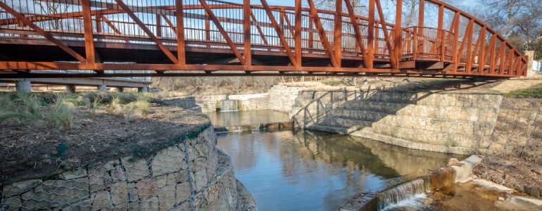 red iron bridge over old dam and trail at Allen Historic Water Station park