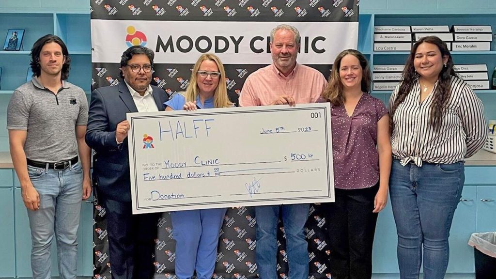 Four Halff employees delivering donation check from HCI to Moody Clinic in Brownsville, Texas