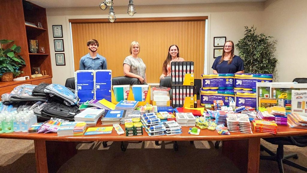 Tavares volunteers with donation school supplies for children