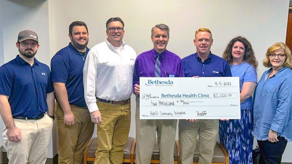 Halff's Tyler office volunteers donating check to Bethesda Health Clinic