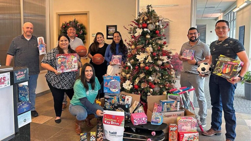 Halff volunteers for HCI in McAllen standing around Christmas tree with donations for Boys and Girls Club of McAllen
