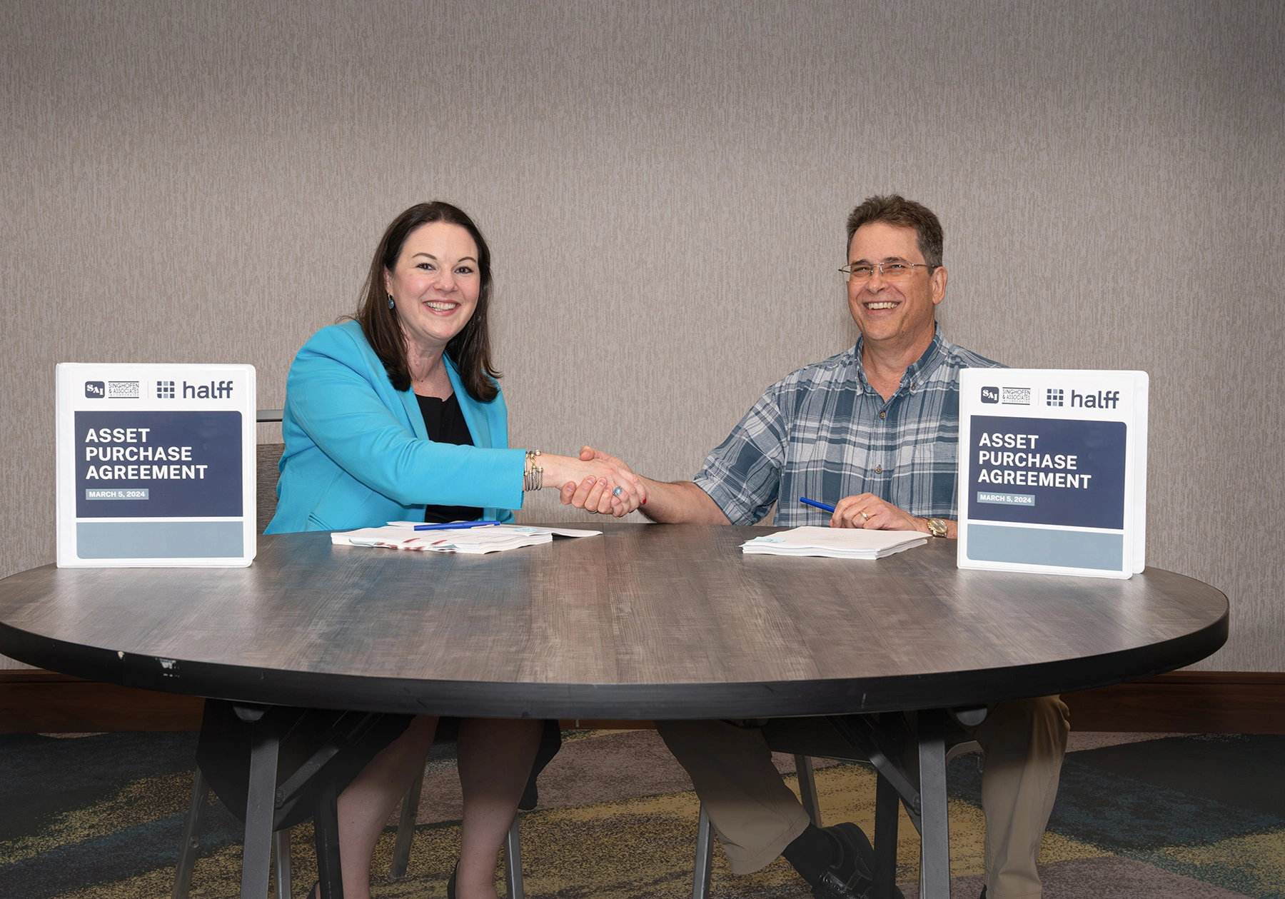 Halff President and CEO Jessica Baker Daily shaking hands with Singhofen President Robert Gaylord in 2024 with the asset purchase agreement. 
