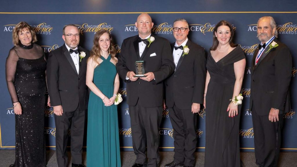 Lineup of Halff attendees at the 2024 ACEC Excellence Awards Gala receiving award on stage