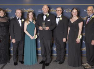 Lineup of Halff attendees at the 2024 ACEC Excellence Awards Gala receiving award on stage